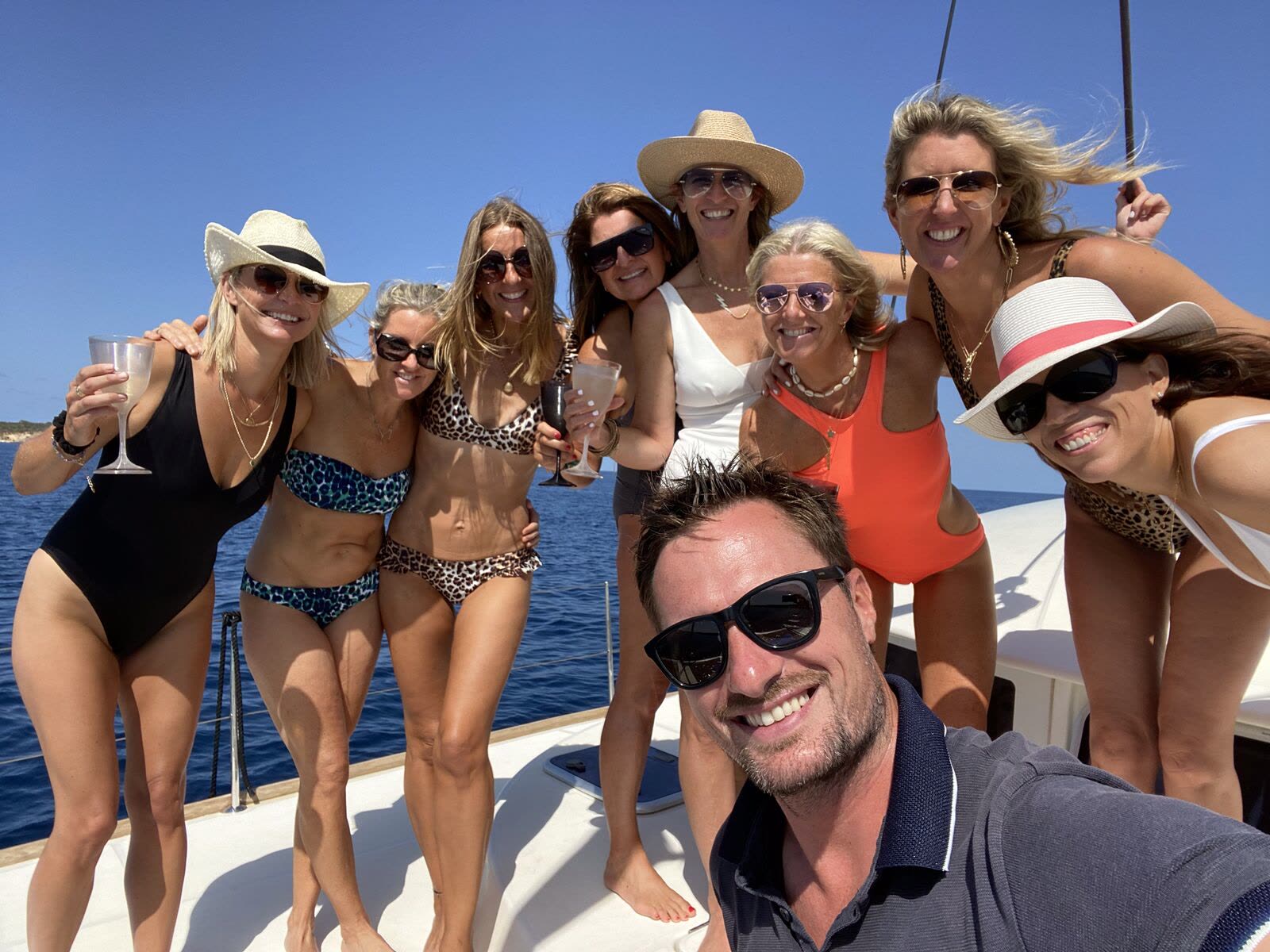 The team and clients of Just Enjoy Ibiza Boats on a catamaran charter